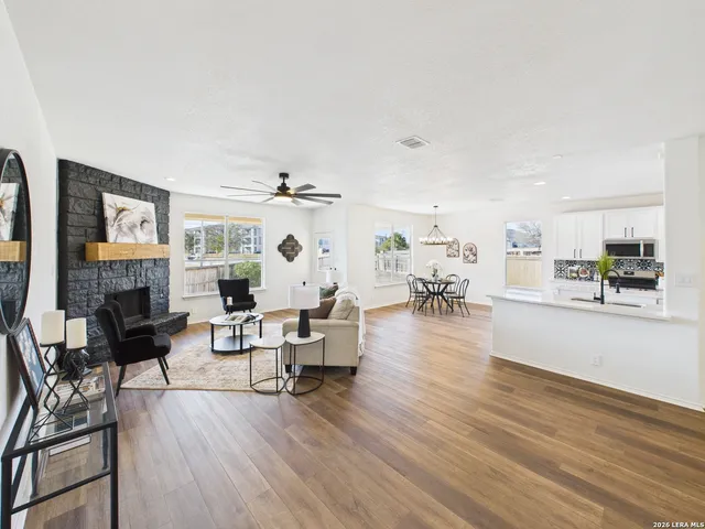 a living room with fireplace furniture and a wooden floor