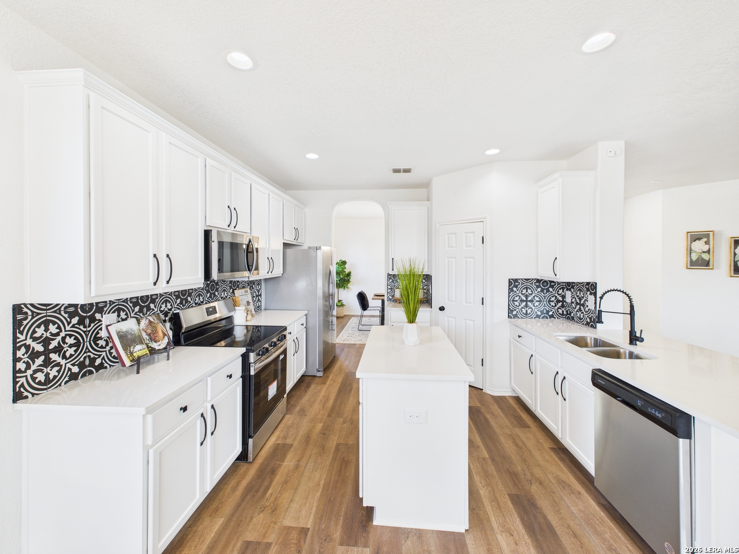 7202 Sandy Bay Converse, TX 78109 - Photo 17 of 40 a large white kitchen with stainless steel appliances granite countertop a lot of counter space and wooden floors
