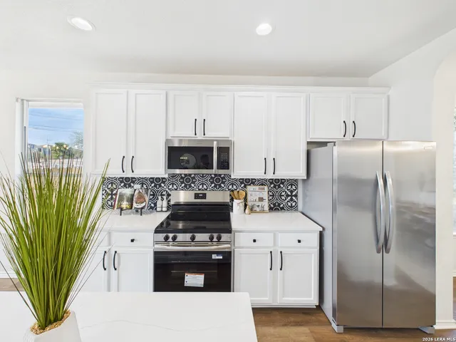 a kitchen with stainless steel appliances kitchen island granite countertop a refrigerator a stove and a sink