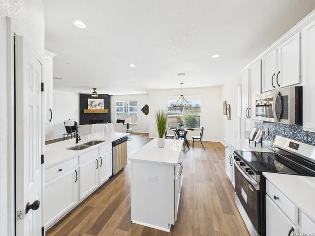 a large kitchen with stainless steel appliances lots of counter space and wooden floor