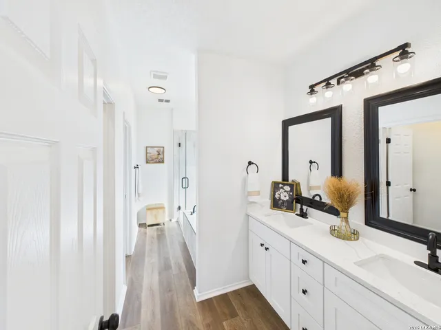 a spacious bathroom with a double vanity sink and a mirror