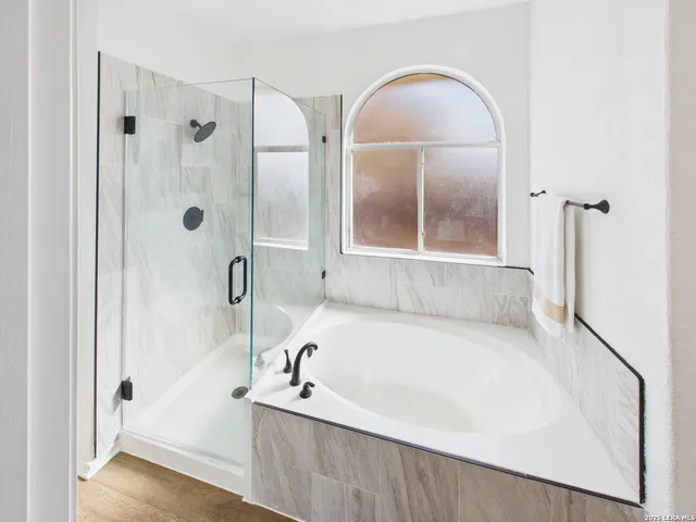 a bathroom with a tub a sink and a large mirror