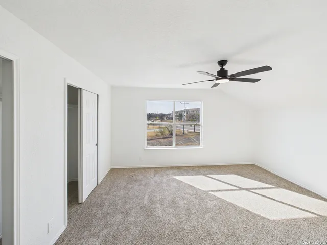a view of a livingroom with a ceiling fan and window