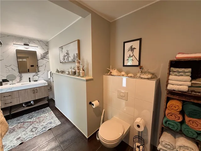 a white toilet sitting next to a bathroom sink