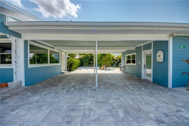 a view of a porch with chairs and potted plants