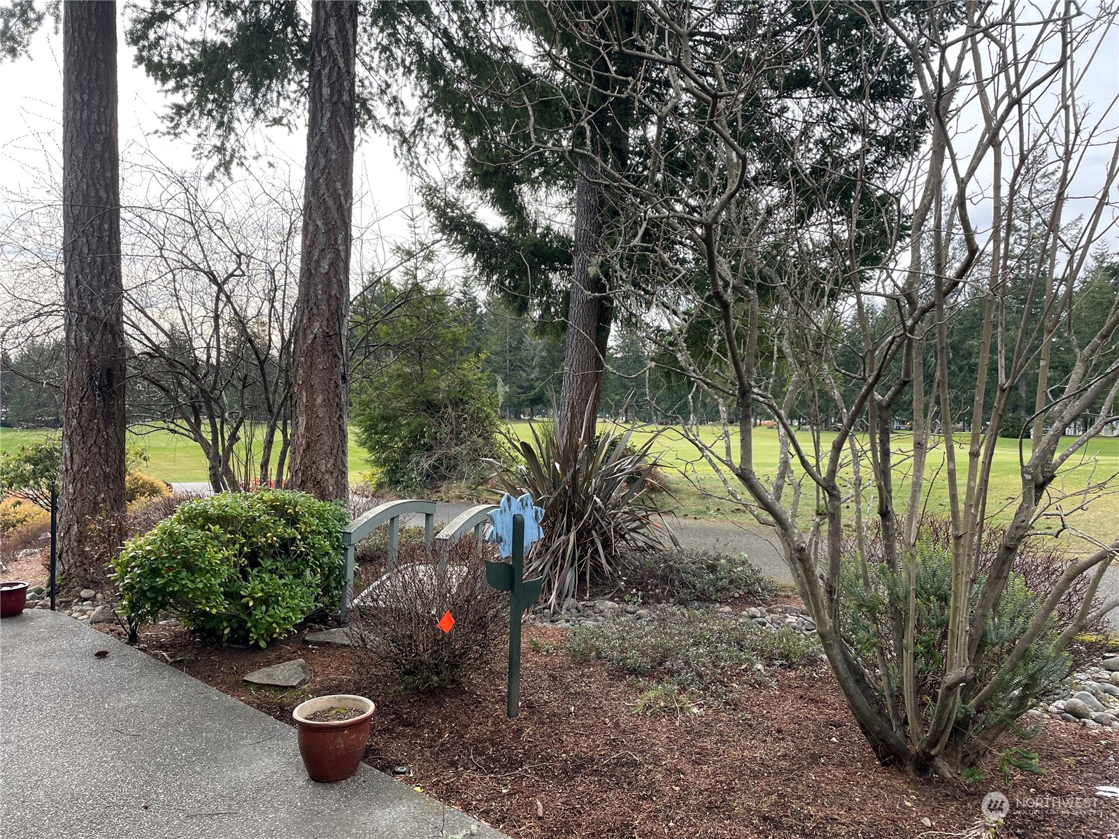 160 East Soderberg Road, Unit E15 Allyn, WA 98524 - Photo 30 of 33 a view of a backyard with plants and large trees