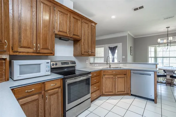 a kitchen with granite countertop a sink stainless steel appliances and cabinets