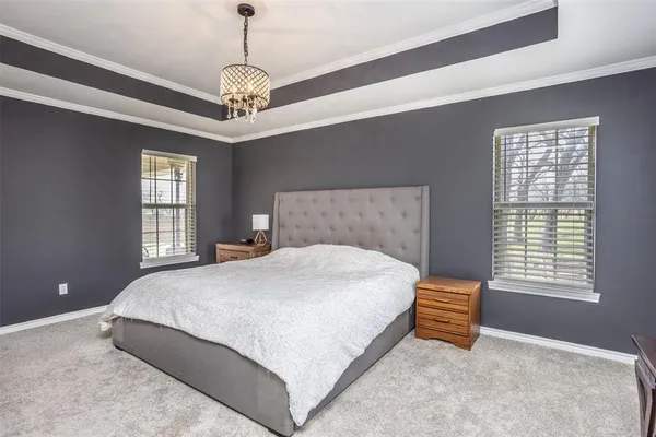a bedroom with a bed and a chandelier