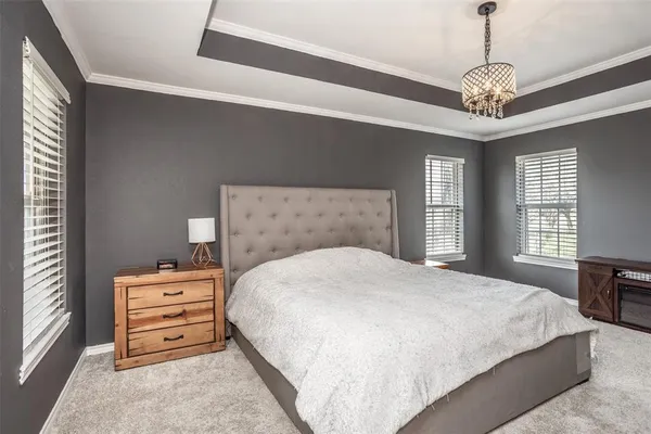 a bedroom with a bed and a chandelier