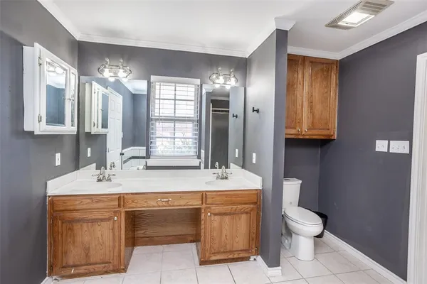 a bathroom with a sink toilet double vanity and mirror