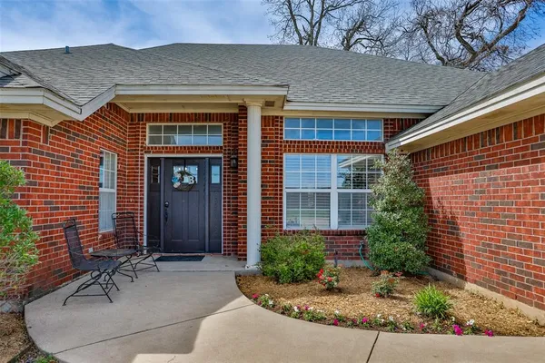 front view of a brick house with a yard