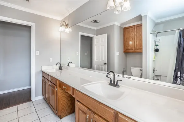 a bathroom with double vanity and a mirror