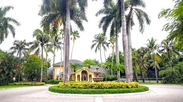 a front view of a house with a garden and fountain