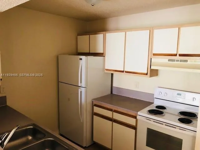 a kitchen with a refrigerator and a sink