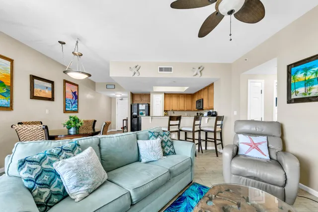 a living room with furniture kitchen view and a chandelier
