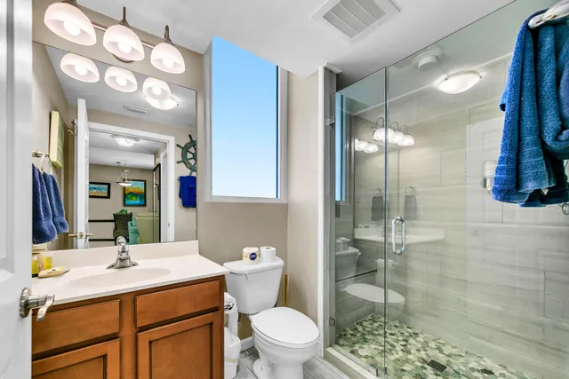 a bathroom with a sink a toilet a mirror and shower