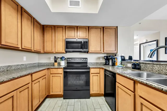 a kitchen with stainless steel appliances granite countertop a stove a sink and a microwave