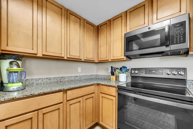 a kitchen with stainless steel appliances granite countertop a stove microwave and cabinets