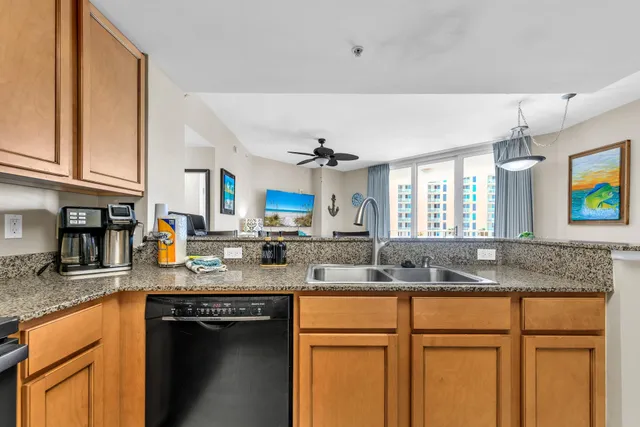 a kitchen with granite countertop a sink stainless steel appliances and cabinets