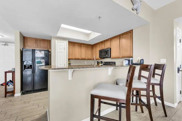 a kitchen with a table chairs refrigerator and cabinets