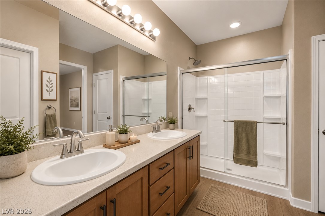 5014 Fiery Sky Ridge Street Las Vegas, NV 89148 - Photo 15 of 21 Double vanity with stone counters and a shower enclosure make this a desirable primary bathroom.