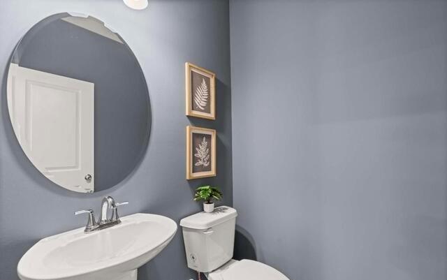1380 Riverstone Road Jonesboro, GA 30238 - Photo 13 of 18 a bathroom with a toilet a sink and mirror