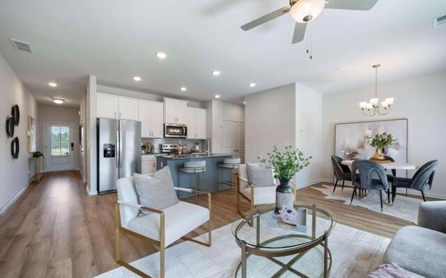 1380 Riverstone Road Jonesboro, GA 30238 - Photo 10 of 18 a view of a dining room kitchen with furniture a chandelier and wooden floor