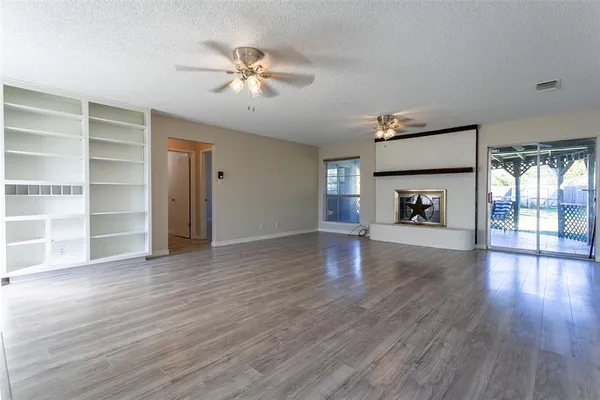 a view of main area fire place window and wooden floor
