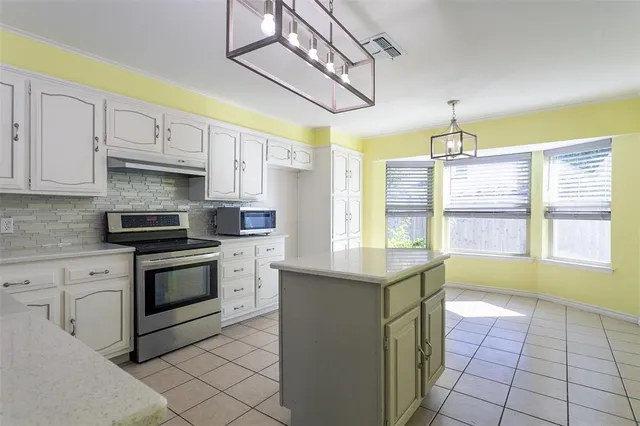 a kitchen with a stove sink and cabinets