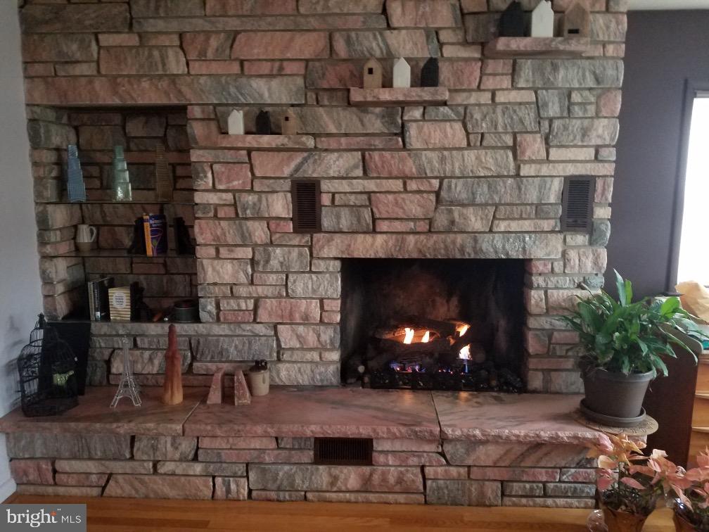 55 East Evesham Road Runnemede, NJ 08078 - Photo 6 of 45 a fireplace with a vase of wine sitting on a table