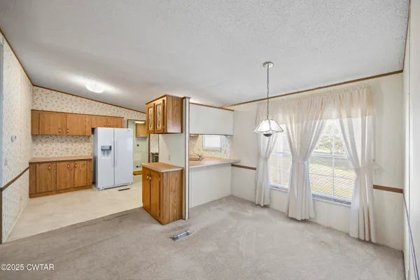 a kitchen with refrigerator and cabinets