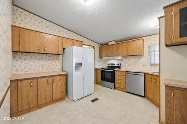 a kitchen with stainless steel appliances granite countertop a refrigerator sink and cabinets