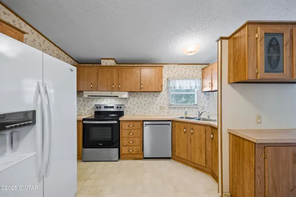 a kitchen with stainless steel appliances granite countertop a refrigerator sink and cabinets