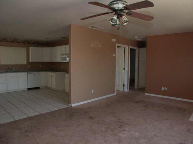 128 North Signal Butte Road Apache Junction, AZ 85120 - Photo 2 of 6 a view of a livingroom with a kitchen space and a ceiling fan