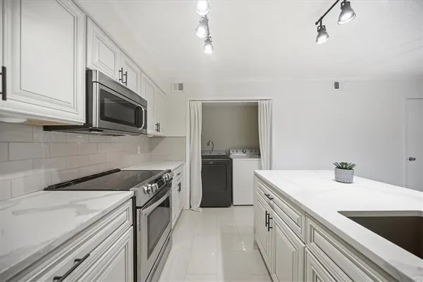 a kitchen that has a sink and a stove top oven