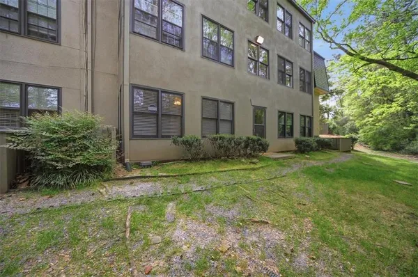 a view of a brick house with a yard and plants