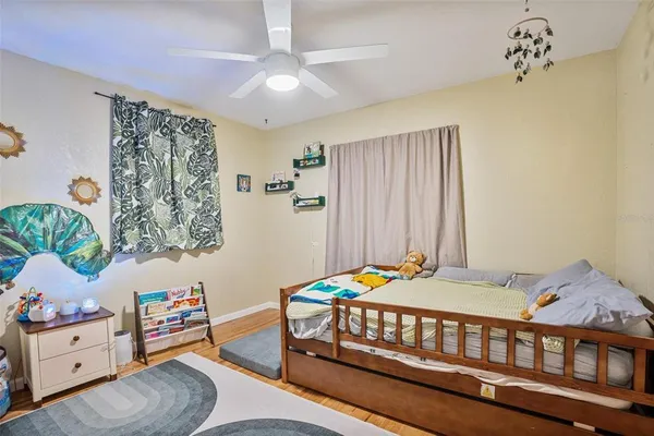 a bedroom with a bed and wooden floor