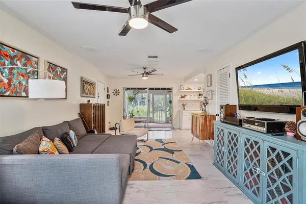 a living room with furniture kitchen view and a flat screen tv