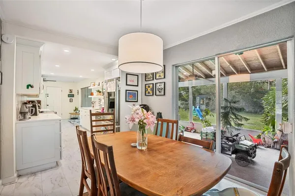 a dining room with furniture a chandelier and wooden floor