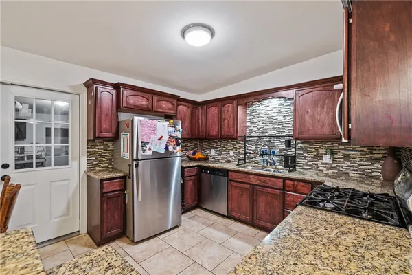 a kitchen with stainless steel appliances granite countertop a refrigerator and a stove top oven