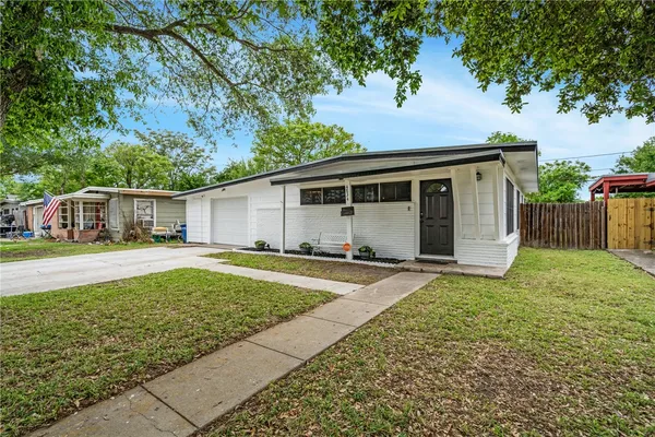 a view of a house with backyard and a tree