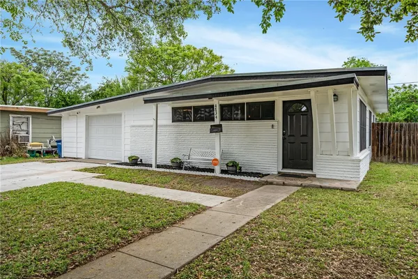a view of a house with backyard and sitting area