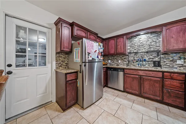 a kitchen with stainless steel appliances granite countertop a refrigerator and a sink
