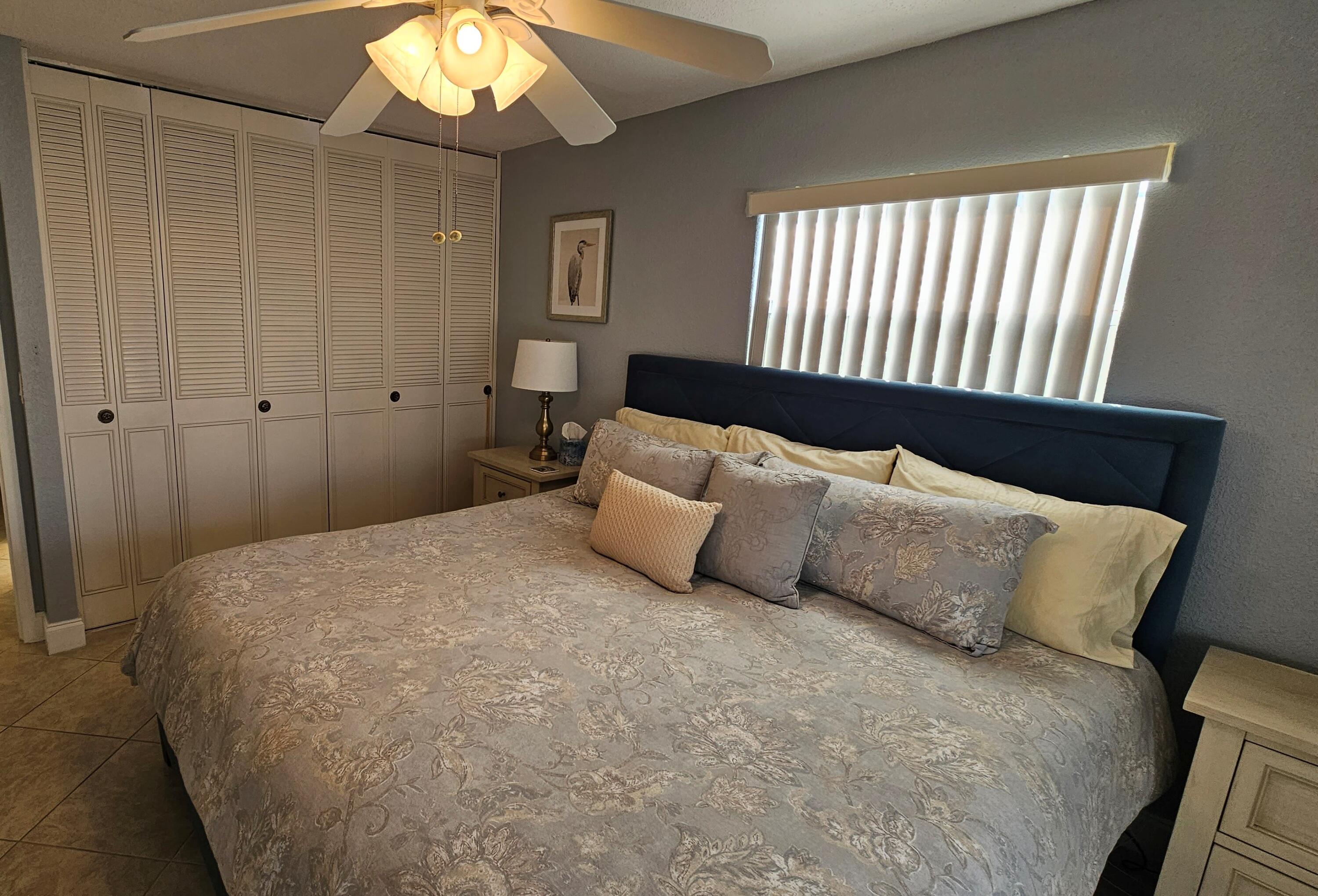 256 Seville K Delray Beach, FL 33446 - Photo 15 of 45 a bedroom with a bed and a chandelier