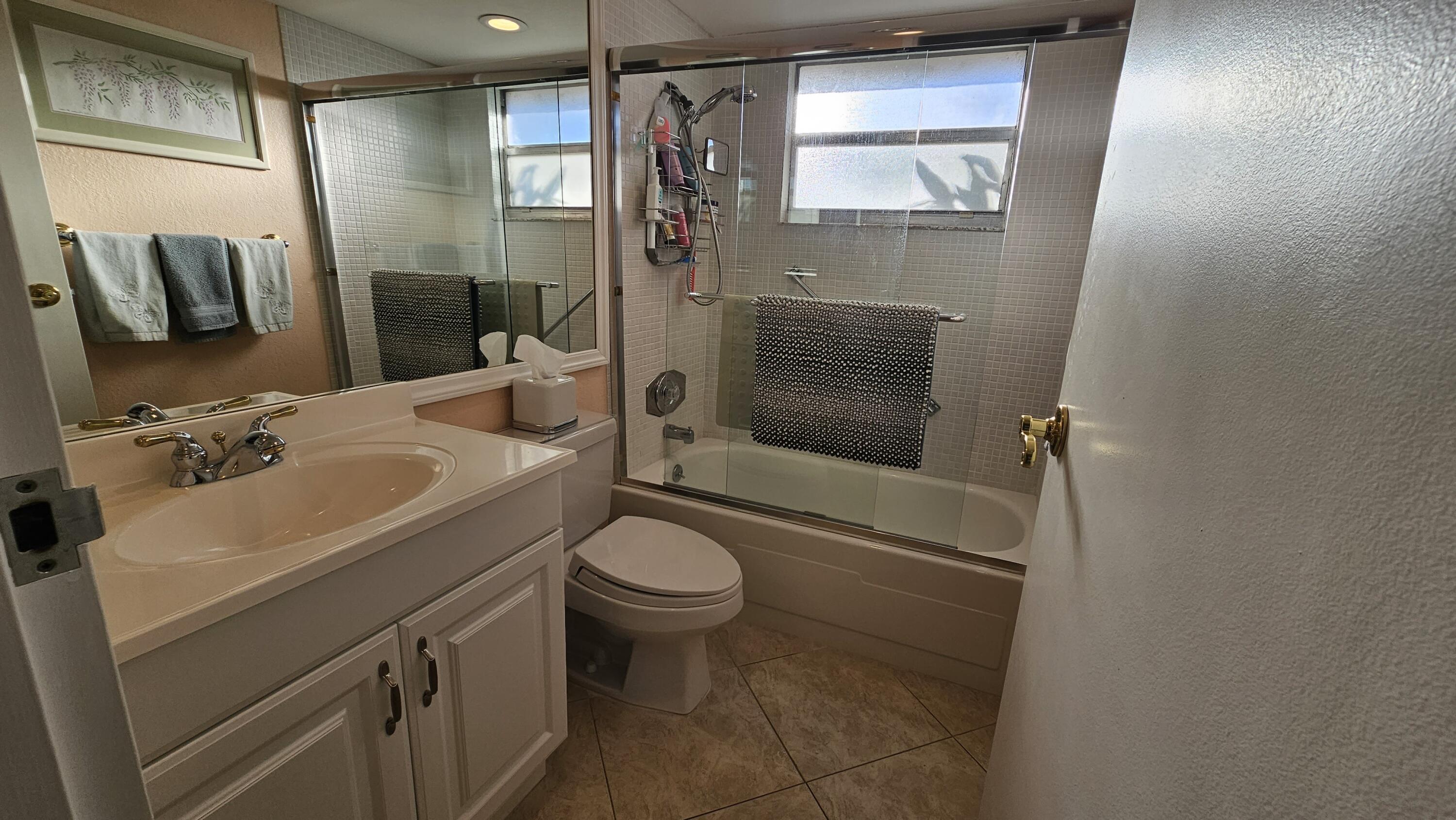 256 Seville K Delray Beach, FL 33446 - Photo 16 of 45 a bathroom with a sink toilet and shower