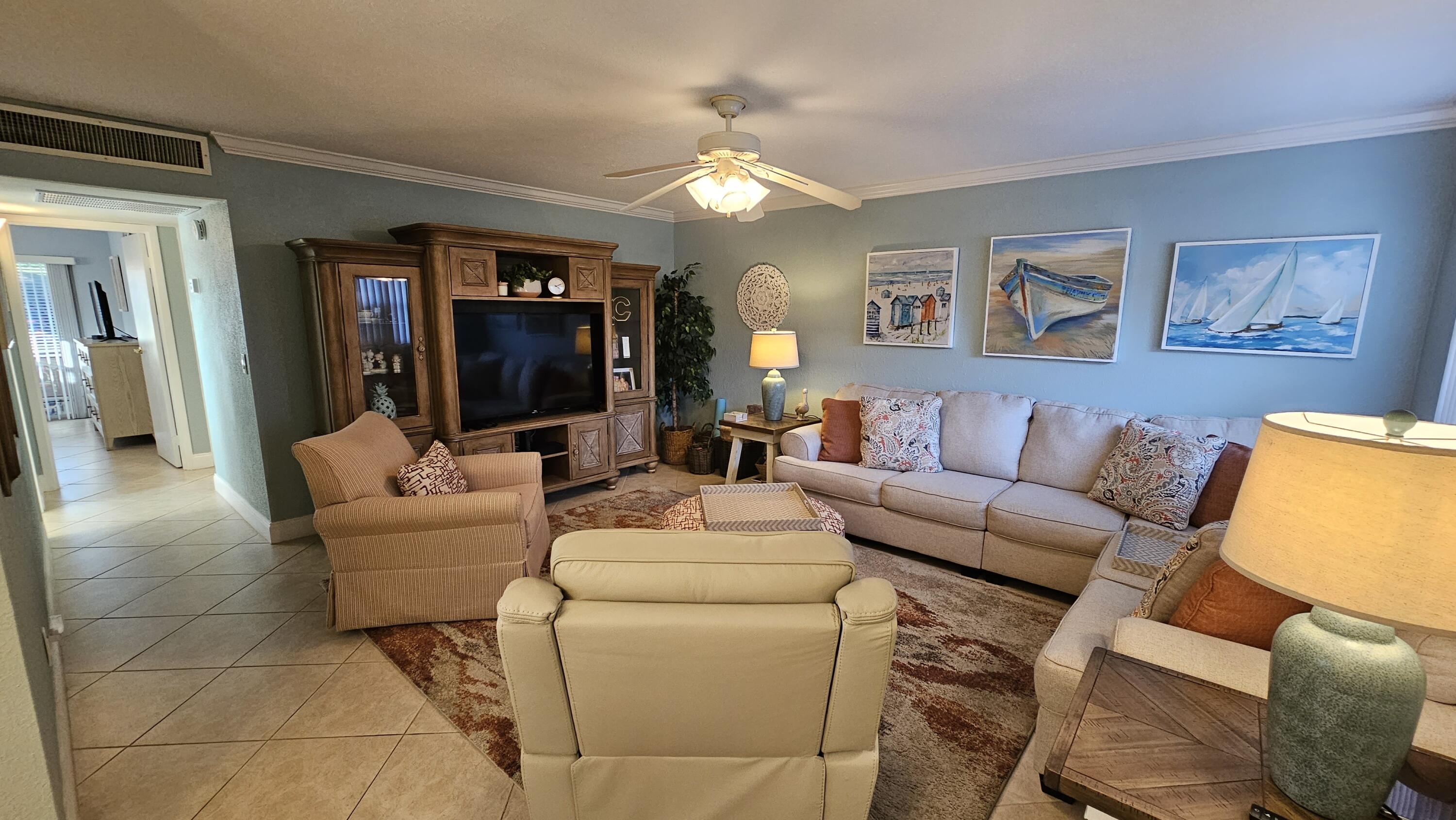 256 Seville K Delray Beach, FL 33446 - Photo 2 of 45 a living room with furniture a mirror and a flat screen tv