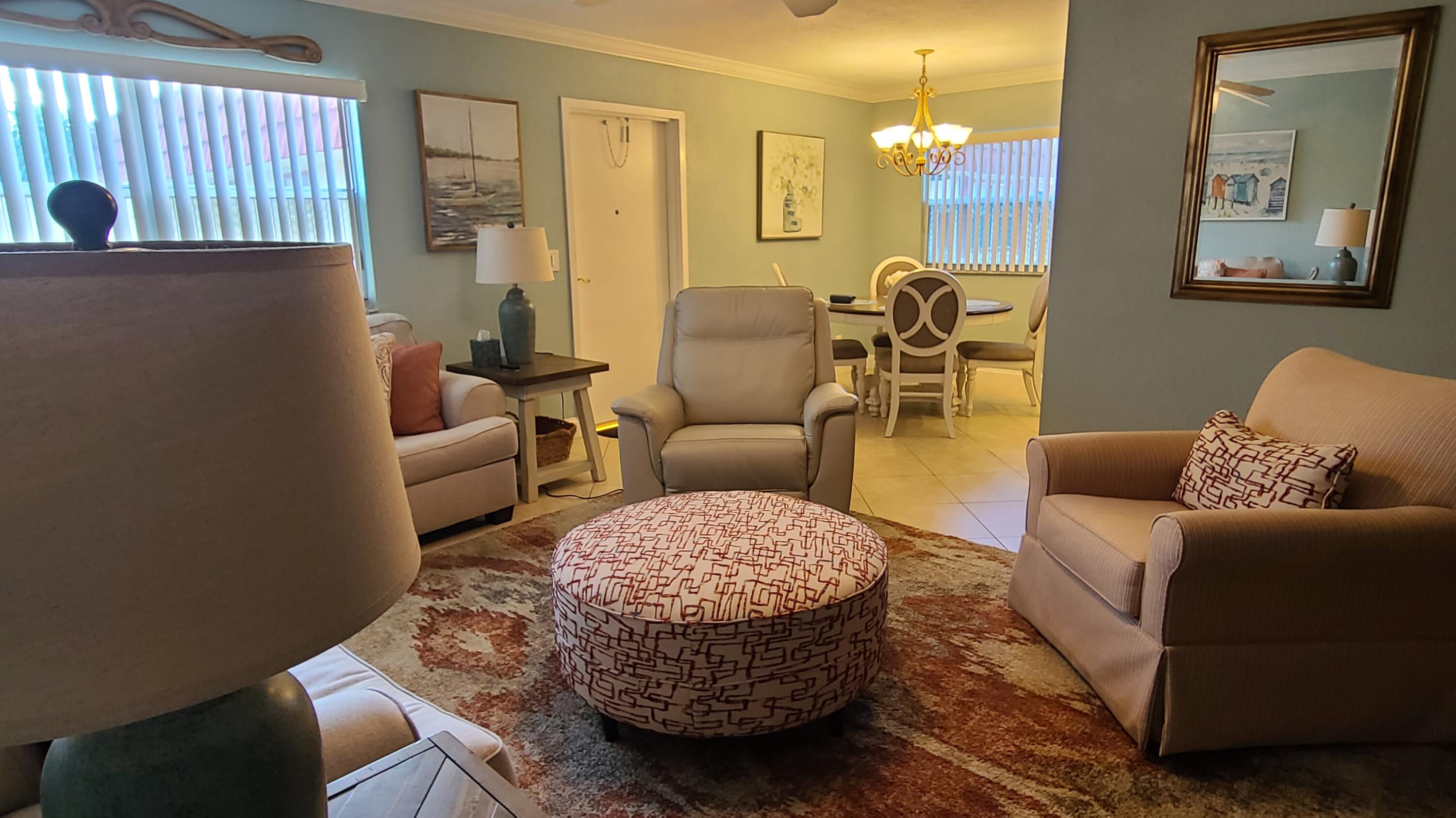 256 Seville K Delray Beach, FL 33446 - Photo 4 of 45 a living room with furniture and a chandelier