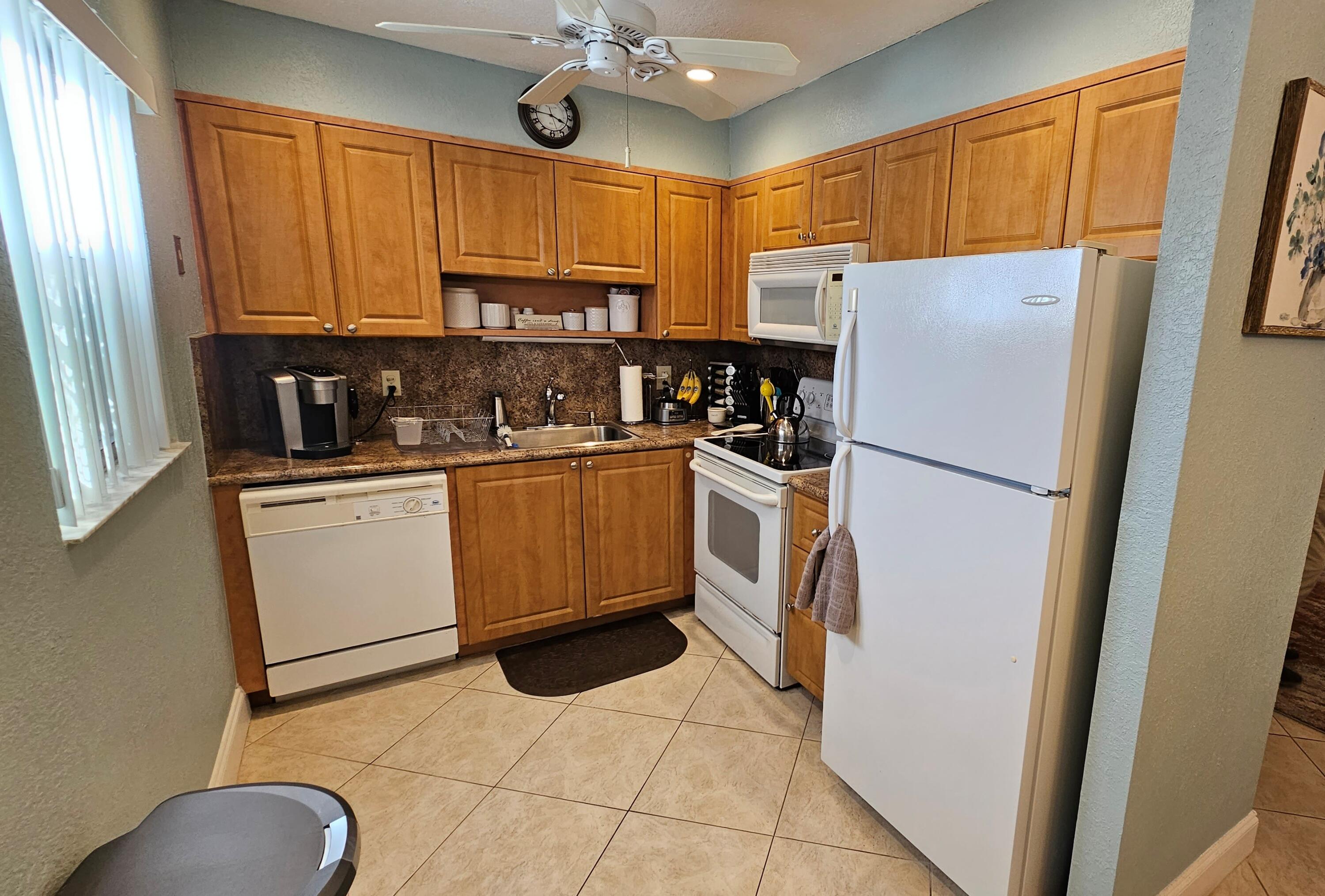 256 Seville K Delray Beach, FL 33446 - Photo 7 of 45 a kitchen with stainless steel appliances a refrigerator sink and cabinets