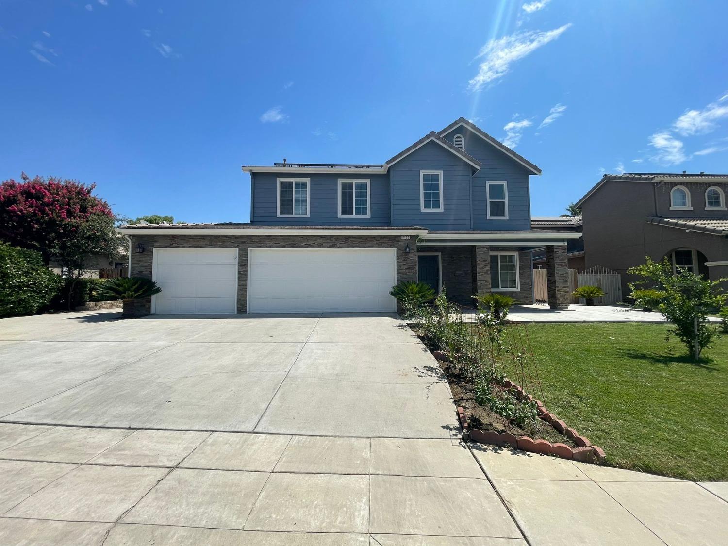 3123 Burgan Avenue Clovis, CA 93611 - Photo 4 of 26 a front view of a house with a yard and a garage