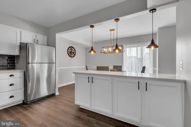 a kitchen with cabinets and wooden floor